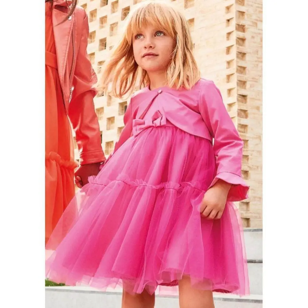 Bambina che indossa un abito cerimonia coprispalle rosa con gonna in tulle elegante