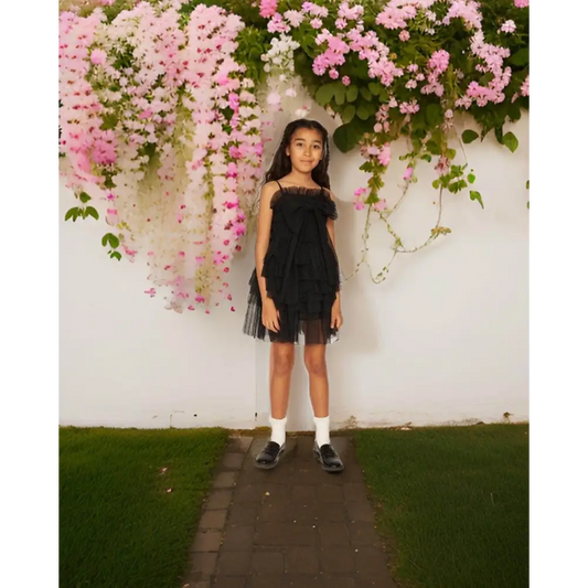 Ragazza in giardino che indossa abito tulle ragazza 8-16 anni nero a balze con spalline sottili e scarpe nere
