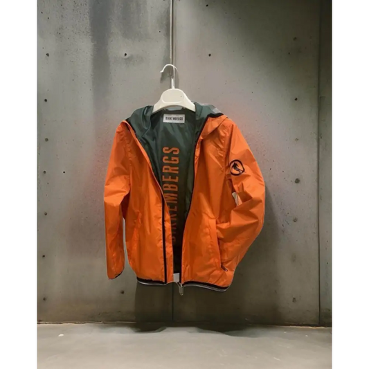 giubbotto leggero ragazzo Bikkembergs arancione con cappuccio fodera verde logo sulla manica zip appeso su parete in cemento