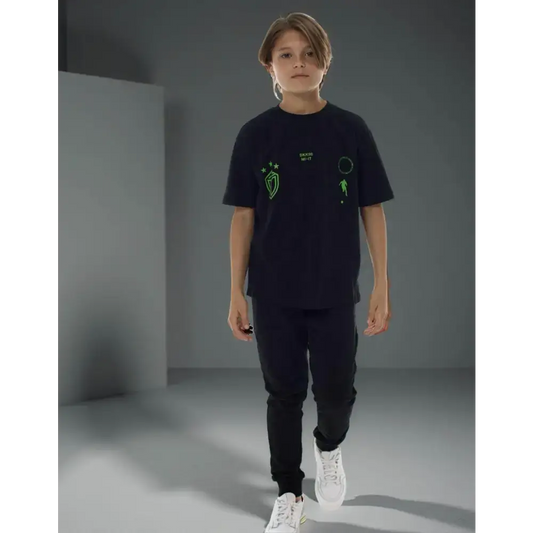 Bambino che indossa t-shirt nera manica corta Bikkembergs con disegni verdi abbinata a pantaloni neri