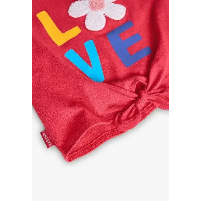 Completo corto bambina estate Boboli con maglia rossa decorata con scritta colorata e fiore bianco