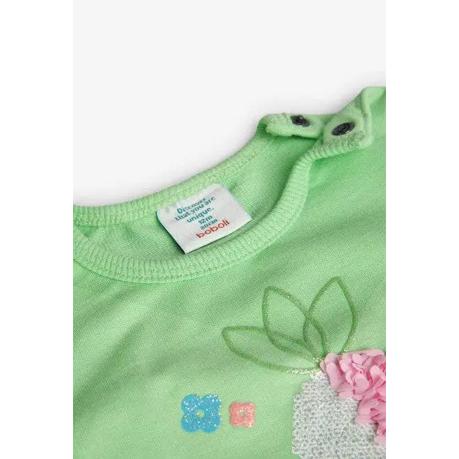 Dettaglio felpa colorata bambina Boboli verde con chiusura a bottoni e decorazioni floreali rosa e azzurre