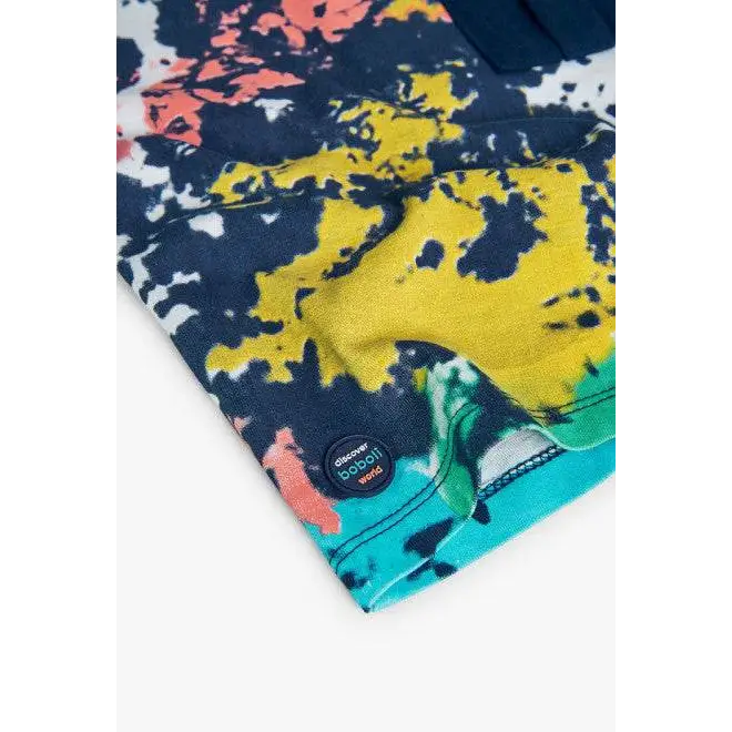 Dettaglio orlo e badge logo su maglietta stampata bimbo Boboli con fantasia a macchie blu giallo turchese e corallo