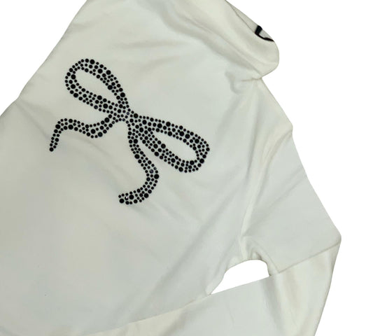 Maglietta dolcevita off-white ragazza con fiocco in strass neri, elegante e alla moda.