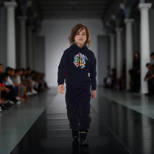 Bambino che indossa FELPA STREET ART LIMITED EDITION BAMBINO nera con stampa colorata e pantaloni abbinati