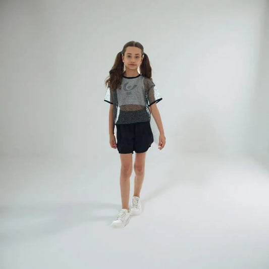 Ragazza che indossa la t-shirt rete Freddy FR1945 grigia trasparente abbinata a pantaloncini neri