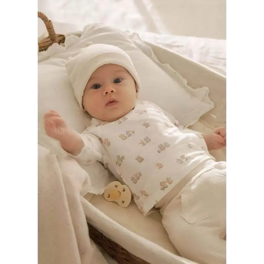 Neonato sdraiato in completo bianco morbidissimo con cappellino nel set regalo neonato Mayoral