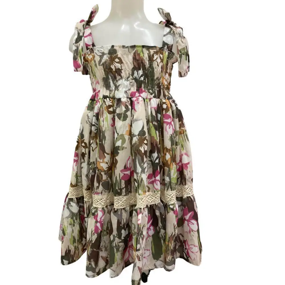 Abito fantasia floreale per bambina. Vestito Paris Hilton con spalline annodate, corpetto smock e gonna a balze con pizzo.