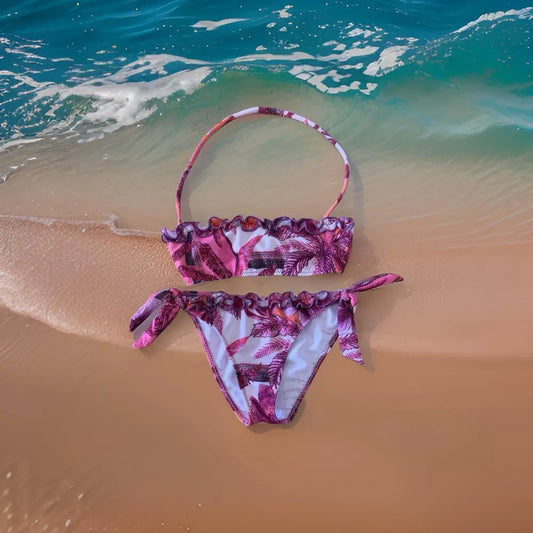 bikini ragazza Paris Hilton stampa tropicale rosa viola top fascia arricciato e slip con laccetti posato sulla sabbia