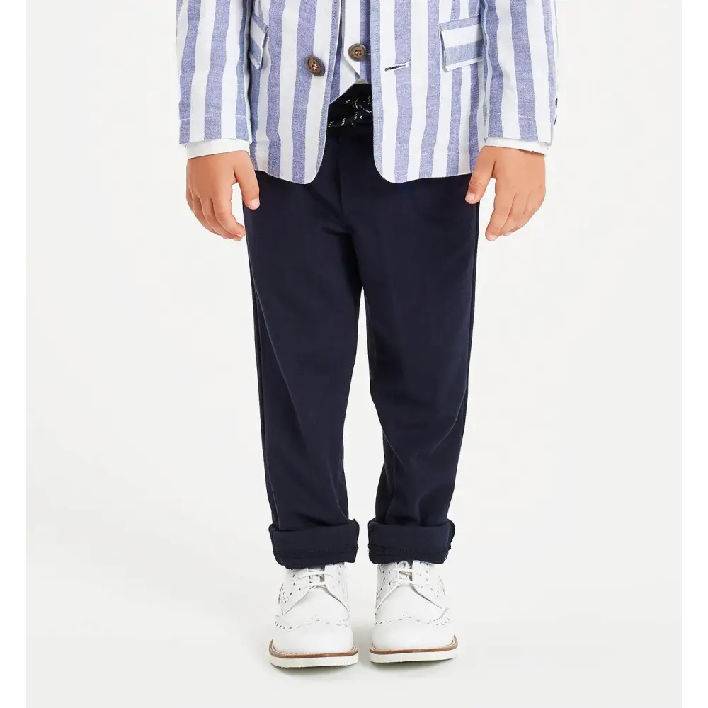 Pantaloni bambino navy Sarabanda in tessuto elegante con risvolto indossati con giacca a righe e scarpe bianche
