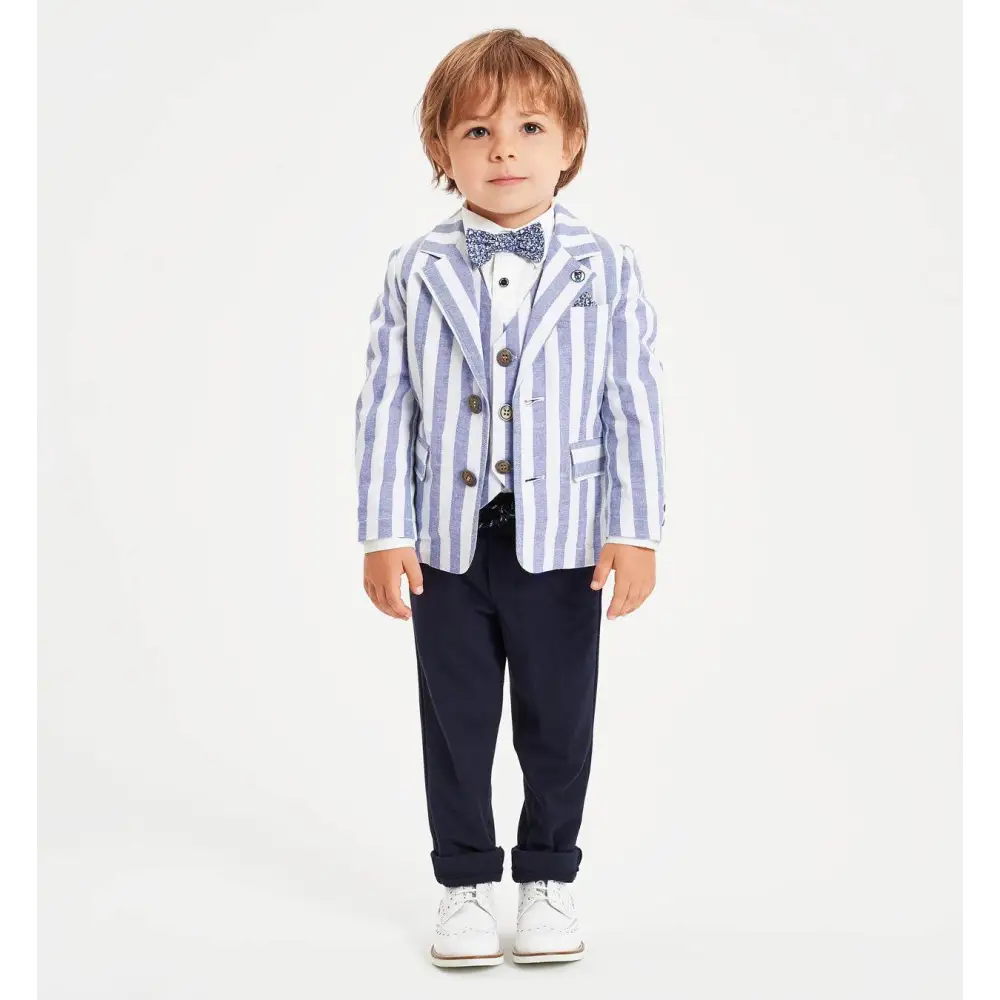 Bambino in posa con pantaloni bambino navy Sarabanda blazer rigato azzurro bianco papillon e sneakers bianche