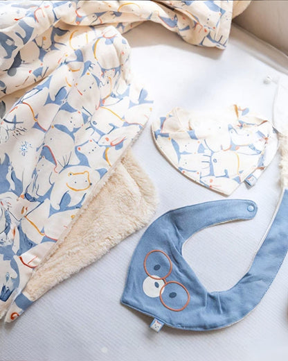 Bavaglino per neonato a maglia con animali azzuro Boboli accanto a copertina e bavaglino a triangolo con stampa animaletti