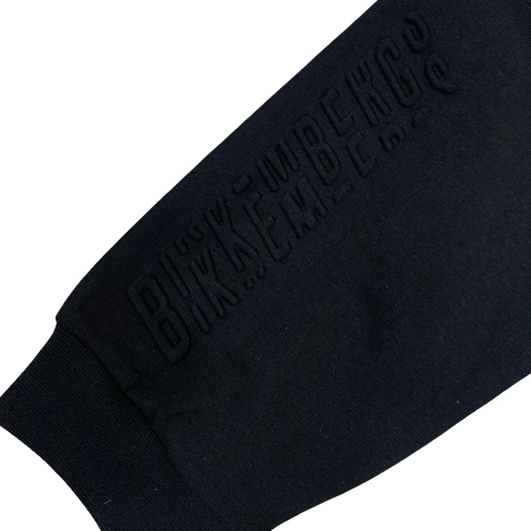 Dettaglio dei pantaloni tuta neri Bikkembergs bambino con logo in rilievo sul tessuto