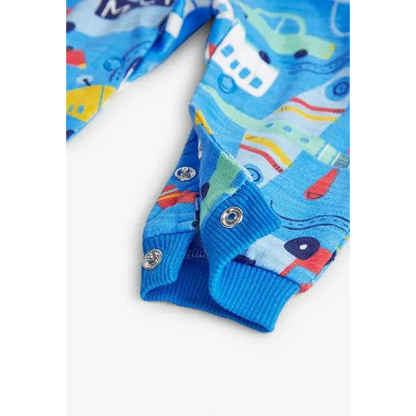 Dettaglio della chiusura con bottoni a scatto di una tutina colorata bambino Boboli in tessuto stampato blu