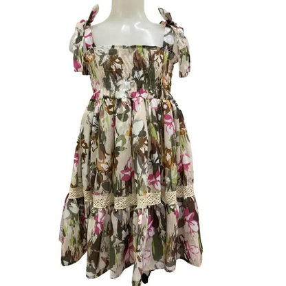 Abito fantasia floreale per bambina. Vestito Paris Hilton con spalline annodate, corpetto smock e gonna a balze con pizzo.