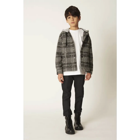 Modello indossa pantaloni eleganti ragazzo 8-16 anni neri slim abbinati a giacca check bianca e stivali