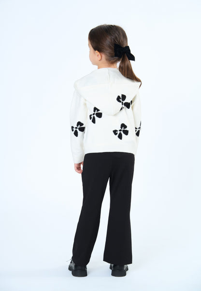 Pantaloni bambina neri eleganti abbinati a un maglione bianco con decorazioni floreali