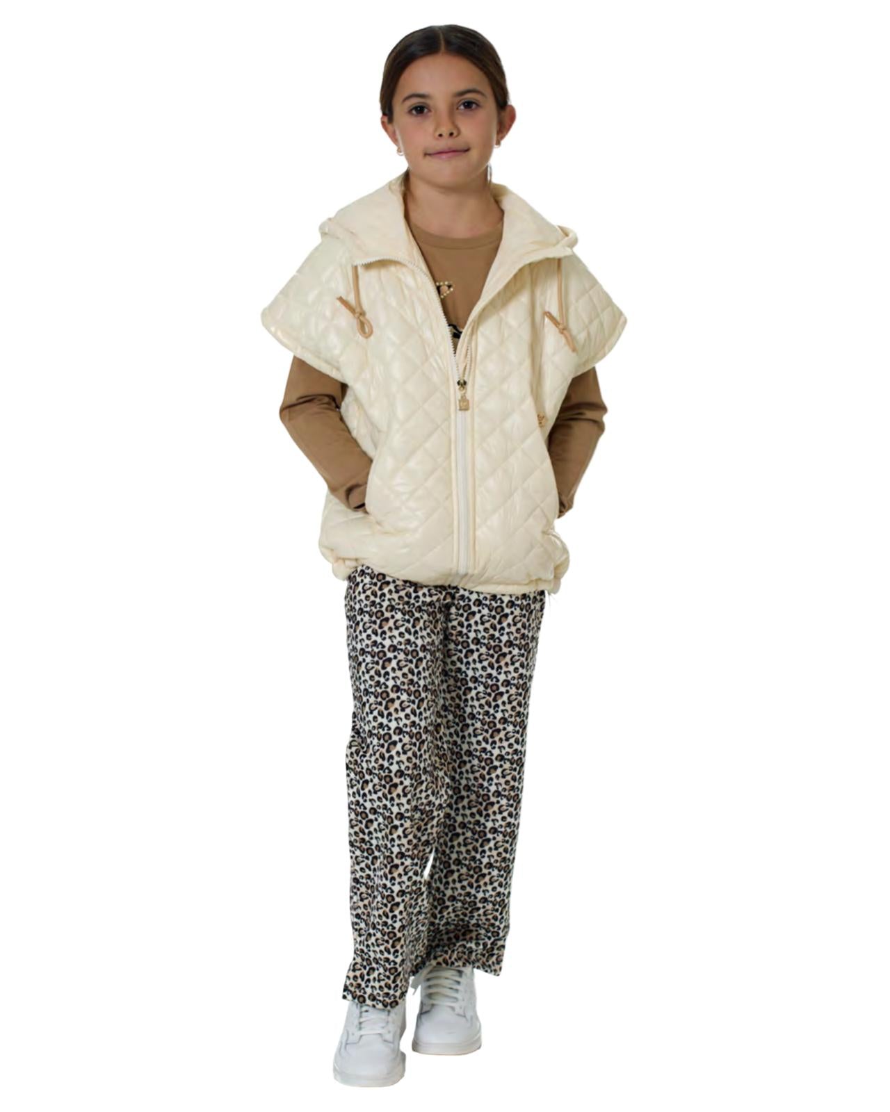 Bambina che indossa pantaloni maculati larghi con elastico e tasche, abbinati a un gilet bianco