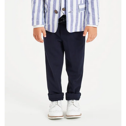 Pantaloni bambino navy Sarabanda in tessuto elegante con risvolto indossati con giacca a righe e scarpe bianche