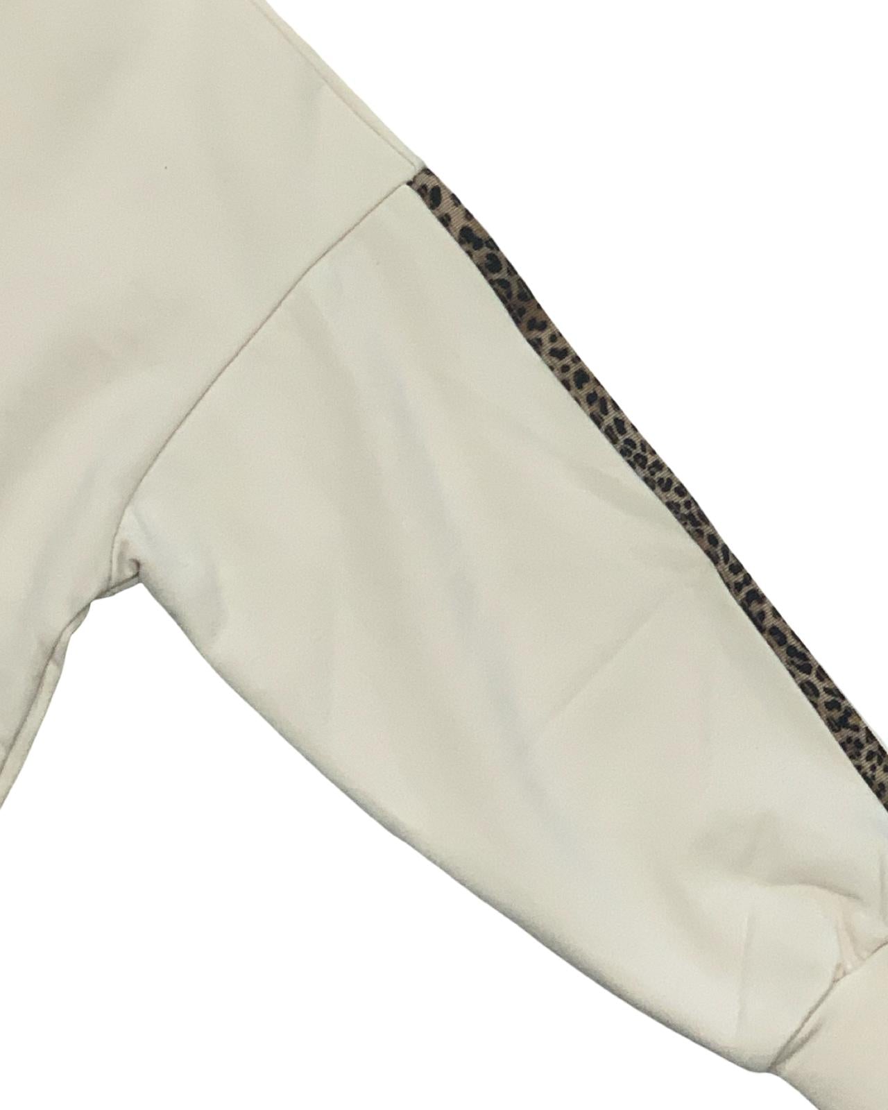 Dettaglio manica della tuta bimba beige due pezzi con motivo leopardato sul bordo