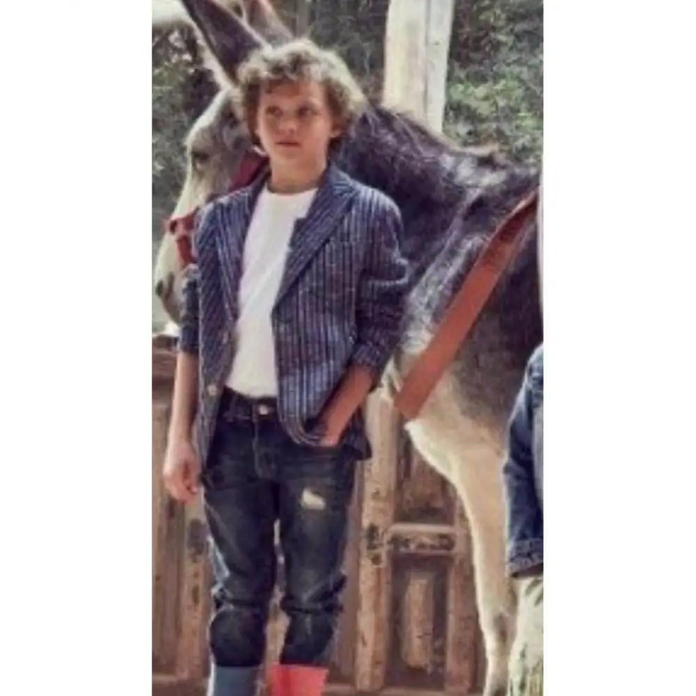 Ragazzo che indossa giacca rigata ragazzo 8 16 anni blu a righe con t shirt bianca e jeans vicino a un asino